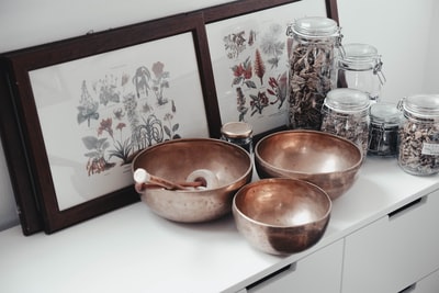 Near framed photos of the stainless steel bowl on the table
